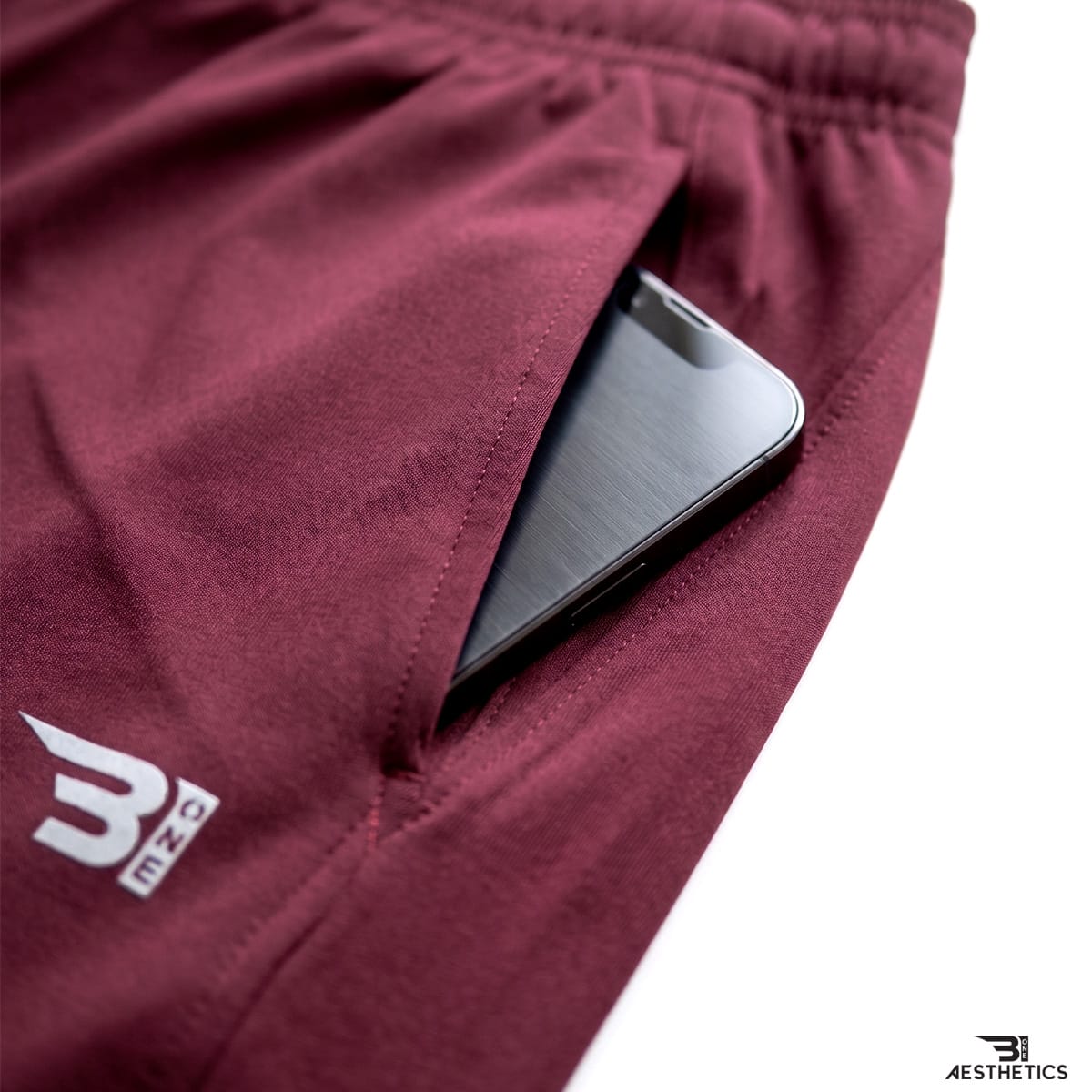 Close up view of men's track bottoms showcasing deep side seam pockets for phone storage